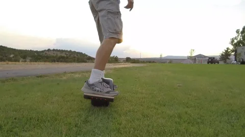 Low Angle Riding OneWheel on Grass HD Stock Footage 97665089