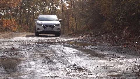 Low angle right slow motion of suv white car driving into water on a mud pat Stock Footage 123217611