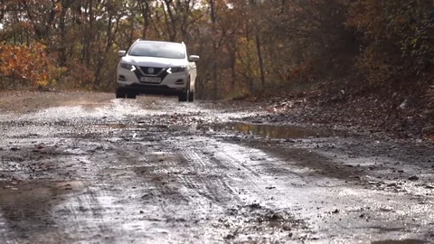 Low angle right of suv white car driving into water on a mud path Stock Footage 123217573