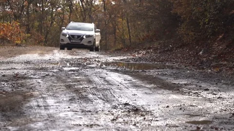 Low angle right of suv white car driving into water on a mud path Stock Footage 123642687