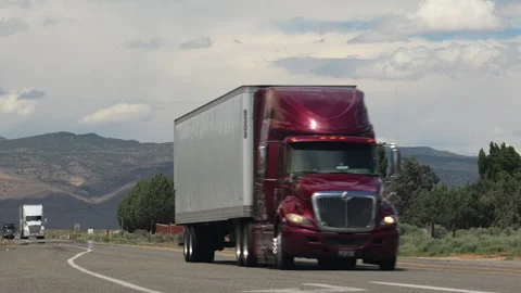 Low angle road shot with red freight truck driving. Benton, California, USA. Stock Footage 287835338