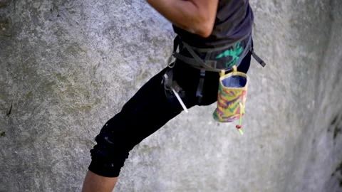 Low angle of rock climber gripping climbing socket on cliff Video stock 131837369