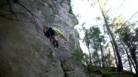 Low angle of rock climber stepping into climbing pocket on cliff Stock-Footage 131838120