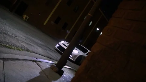 Low angle rolling shot of a Porsche Panamera turning a corner at night Stock-Footage 127164533