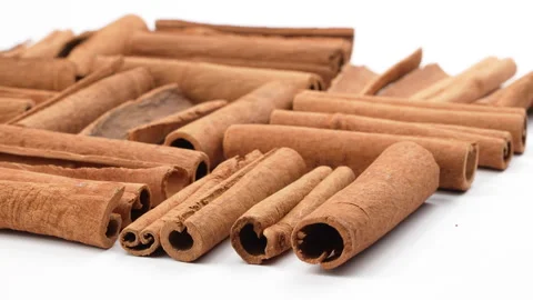 Low Angle Rotating Cinnamon Sticks On White Background Видео 331385843