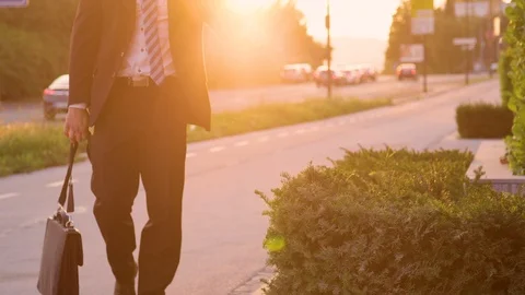 LOW ANGLE: Sad young businessman carrying his briefcase after a bad day at work. Video stock 101335468