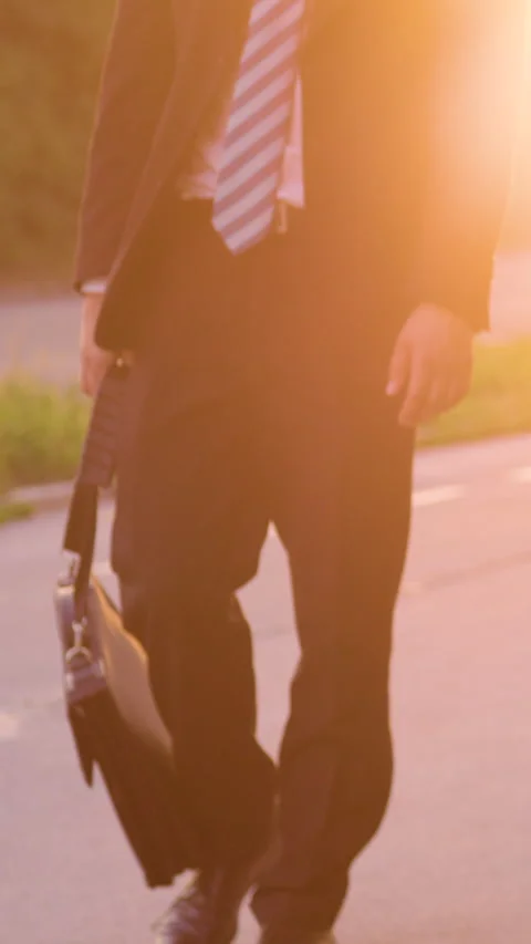 LOW ANGLE: Sad young businessman carrying his briefcase after a bad day at work. Video stock 280800547