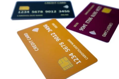Low-angle scattered arrangement of three colorful credit cards featuring or.. Stock Photos
