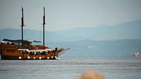 Low angle sea-level view of old wooden pirate tourist ship passing by Stock Footage 164283343