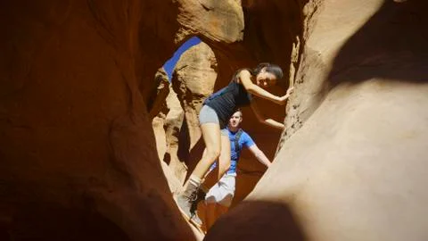 Low angle selective focus view of boyfriend and girlfriend exploring cave in 스톡 사진