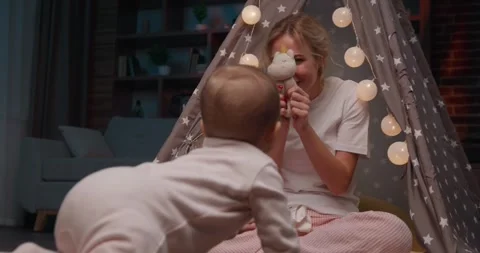 Low angle shot of an adorable small girl crawling on the floor to her mom. Stock Footage 242176797