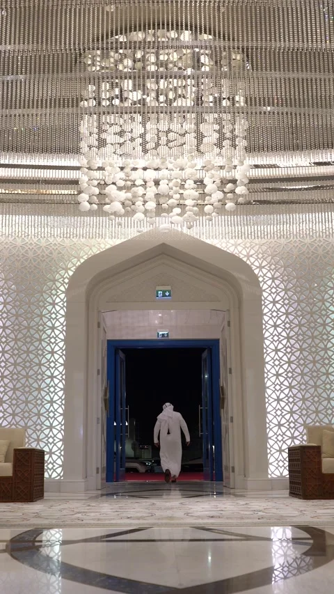 Low angle shot of an Arab man in a white thobe walking out of a magnificent Stock Footage 341141989