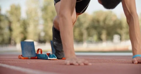 Low angle shot of an athlete putting feet on starting blocks on stadium track Stock-Footage 118930836