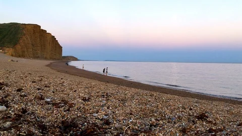 Low angle shot of the beach and cliffs in West Bay Stock Footage 94363550
