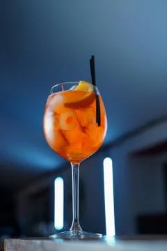 Low angle shot of bitter Aperol spritz on blue neon background Stock Photos