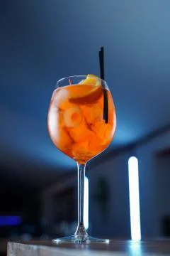 Low angle shot of bitter Aperol spritz on blue neon background Stock Photos