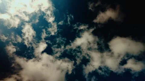 Low-angle shot of a blue sky with white clouds, spinning or rotating in a circle Stock Footage 321273667
