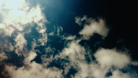 Low-angle shot of a blue sky with white clouds, spinning or rotating in a circle Stock Footage 321273728