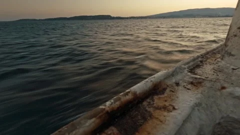 Low Angle Shot of Boat Sailing on Calm Sea Water During Dusk with Kefallonia Stock Footage 328306584