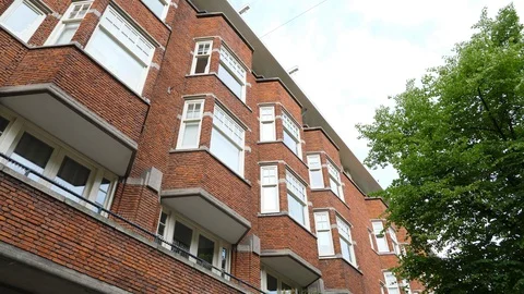 Low angle shot of brick building, multi-unit apartment house at Amsterdam Stock Footage 129891457