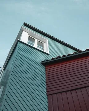 Low angle shot of a building with pattern exterior and a white window against a Stock Photos