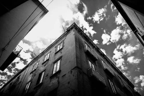 Low angle shot of a building with windows under a cloudy sky in black and whi 写真素材