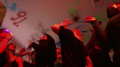 Low angle shot of a bunch of young people dancing at a hip house party. Vidéo 295230349