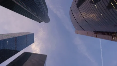 Low angle shot of camera rotating in front of modern, skyscrapers made of glass Stock Footage 104825879
