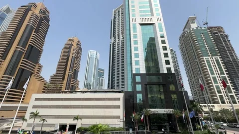 A low-angle shot captures Dubai's towering skyscrapers piercing the bright bl Stock Footage 313388285