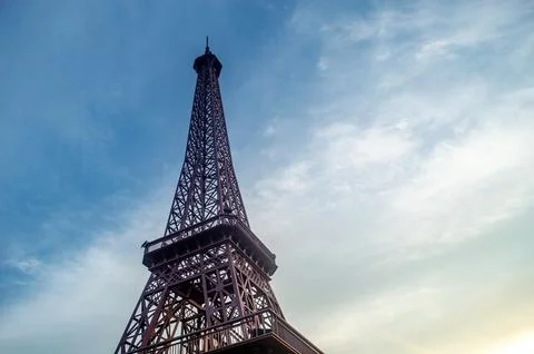 A low angle shot captures the eiffel tower against a bright sky with soft c.. Stock Photos
