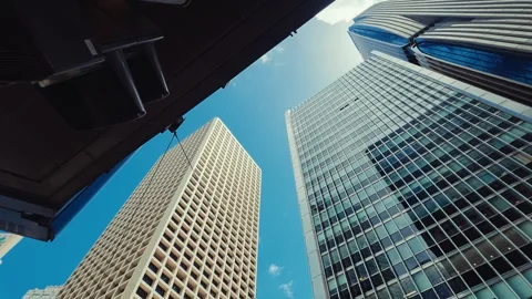 A low-angle shot captures towering modern skyscrapers in Hong Kong against a Stock Footage 338311501