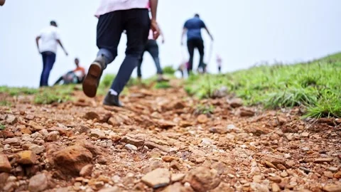 A low-angle shot captures a young student running up a rugged mountain path.. Video stock 313381311