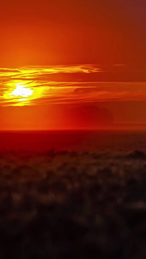 Low angle shot capturing sun setting down with thick clouds blocking sunrays on Stock Footage 317624822