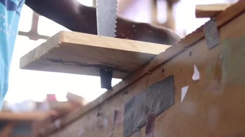 Low angle shot of a carpenter cutting wood with saw. Sawing wood Stock Footage 223790492