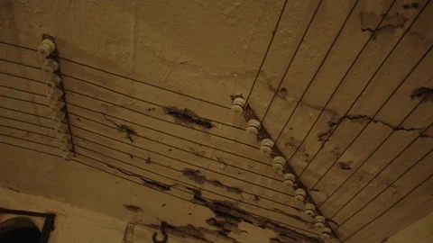 A low-angle shot of a ceiling with exposed wires and white ceramic insulators Video stock 301033467