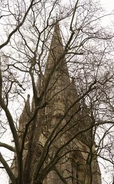 A low-angle shot of a church with bare trees in the foreground, highlighting  Stock-Fotos