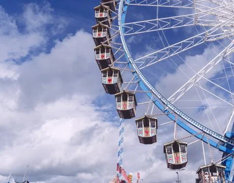 Low angle shot of a circular carousel revolving under a sky full of clouds Stock Photos
