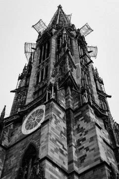 Low angle shot of the clock tower of Freiburg cathedral Stock Photos