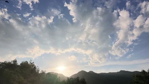Low angle shot of clouds over mountains at sunset Stock Footage 345484918
