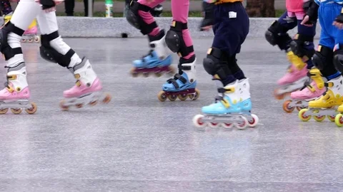 Low angle shot of coach and children ride in a roller-skating at park Video stock 84664453