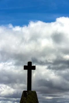 Low angle shot of a cross statue under a cloudy sky Stock Photos