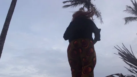 Low angle shot of dancer against sky and palm trees Stock Footage 72794607