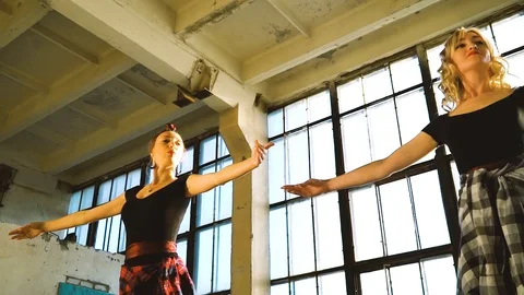 Low angle shot of dancers warming up in loft studio with pigeon flying inside Stock Footage 114429518