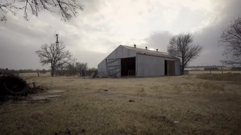 Low Angle Shot of Detriorated Abandon Barn in WIndy FIeld Dystopian Push in Shot Stock-Footage 157499863