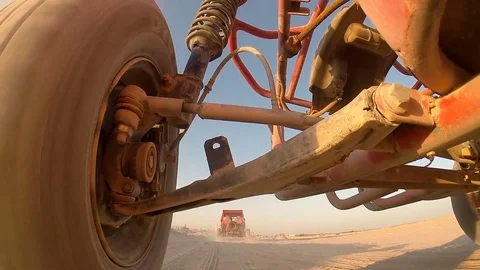 Low angle shot of dune buggies driving in a line through the desert Vídeo Stock 85058122