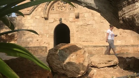 Low Angle Shot During rain of a woman walk out from an old church Stock Footage 83205553