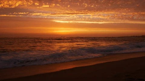 Low angle shot at dusk on beach with beautiful orange / red sky Stock Footage 111167435