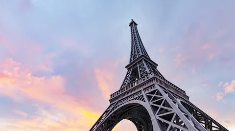 Low angle shot of the Eiffel tower under a beautiful sunset sky in Paris Stock Photos