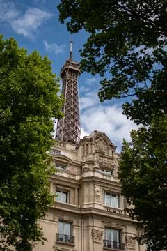 Low-angle shot of the Eiffel Tower and a traditional building in Paris Stock Photos