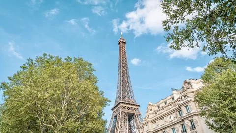 Low angle shot of the Eiffel Tower standing tall behind ol buildings in Paris, F 스톡 사진